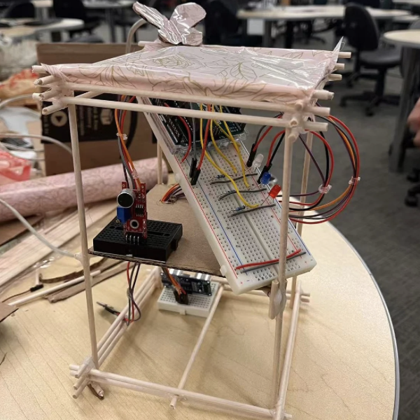 Assembling the prototype with sensors, wires, Arduino, and paper panels attached to the wooden frame.